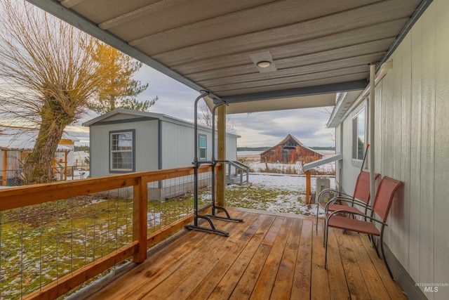 snow covered deck featuring a shed