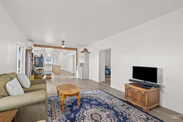 living room featuring ceiling fan, light hardwood / wood-style floors, and a wall mounted air conditioner