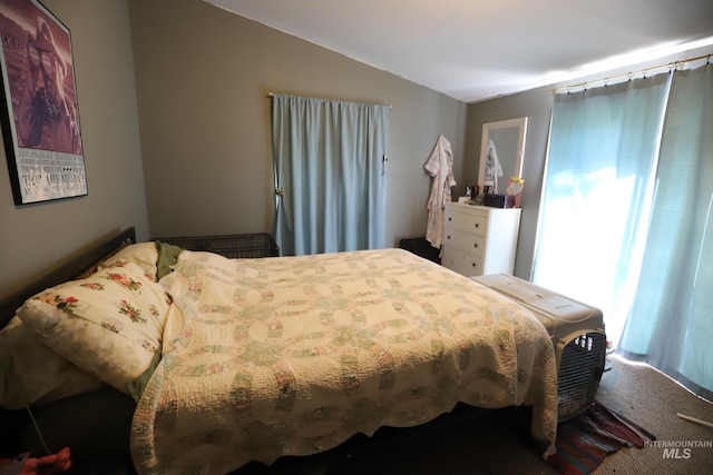 carpeted bedroom with lofted ceiling