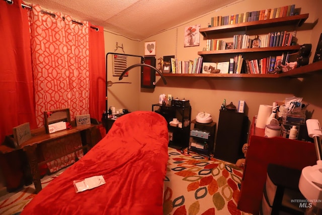 bedroom with lofted ceiling and a textured ceiling
