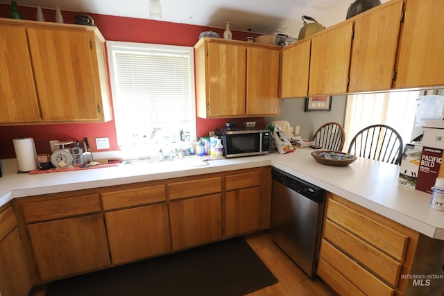 kitchen with a peninsula, light countertops, light wood-style floors, and appliances with stainless steel finishes