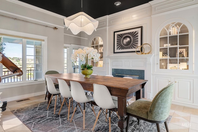 176 Marine View Dr, Lewiston, ID 83501 - dining area featuring built in shelves, a premium fireplace, light tile patterned floors, baseboards, and crown molding