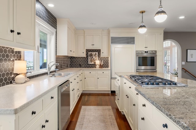 176 Marine View Dr, Lewiston, ID 83501 - kitchen with stainless steel appliances, a sink, arched walkways, dark wood-type flooring, and hanging light fixtures