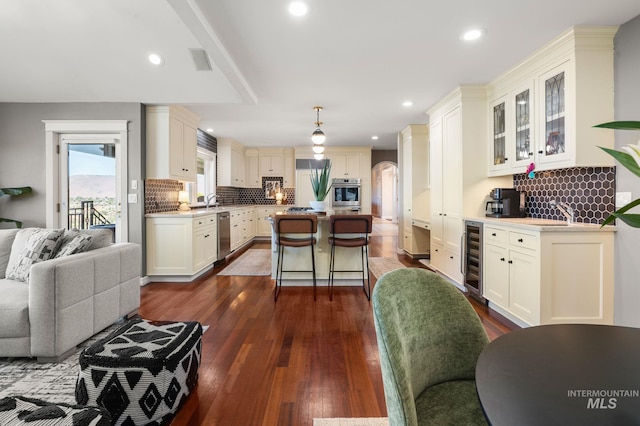 176 Marine View Dr, Lewiston, ID 83501 - kitchen featuring appliances with stainless steel finishes, a center island, wine cooler, decorative backsplash, and glass insert cabinets