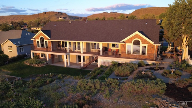 176 Marine View Dr, Lewiston, ID 83501 - back of house featuring a patio area, brick siding, a lawn, a deck with mountain view, and stairs