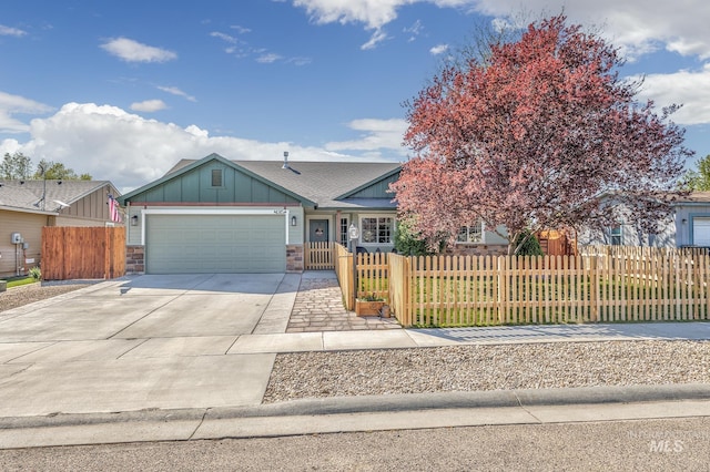 ranch-style house with board and batten siding, a fenced front yard, concrete driveway, and a garage