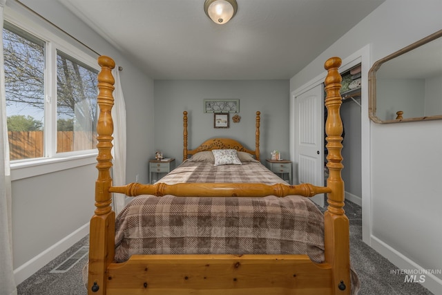 carpeted bedroom with a closet, visible vents, and baseboards