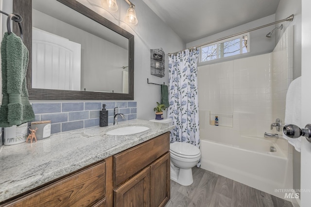 full bath with shower / bath combination with curtain, wood finished floors, toilet, vanity, and tasteful backsplash