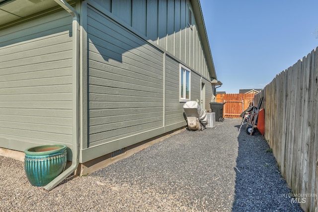 view of side of home with board and batten siding and a fenced backyard