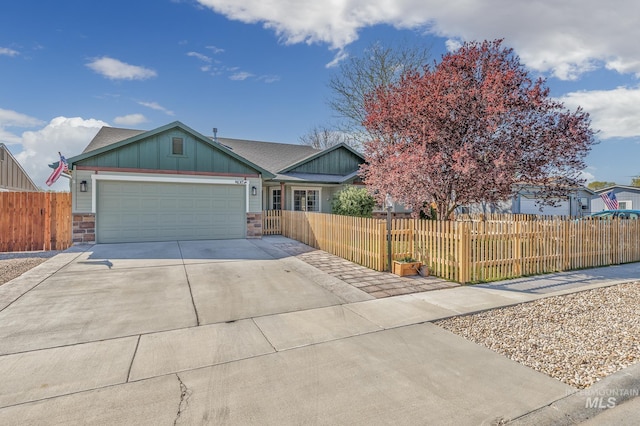 single story home featuring board and batten siding, an attached garage, a fenced front yard, and driveway