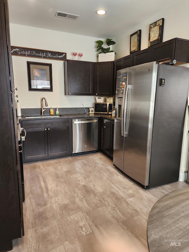 1018 S Washington Ave, Emmett, ID 83617 - kitchen with dark brown cabinets, stainless steel appliances, light hardwood / wood-style floors, and sink