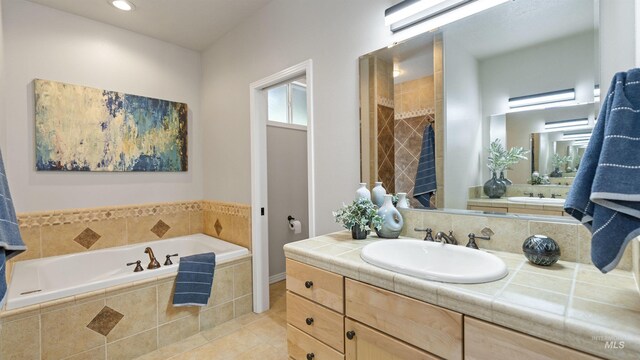 full bath featuring a garden tub, tile patterned floors, vanity, and recessed lighting