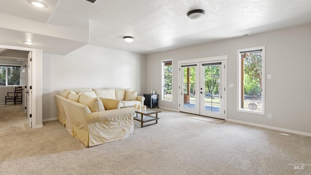 living room featuring carpet, plenty of natural light, and french doors