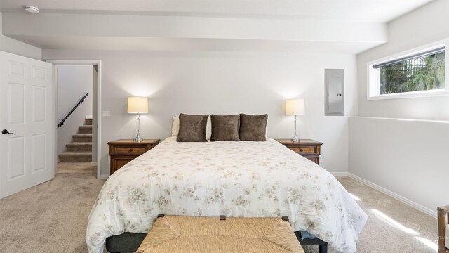 bedroom featuring light colored carpet, electric panel, and baseboards