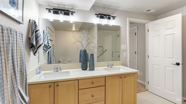 full bath with a stall shower, toilet, tile patterned flooring, and double vanity