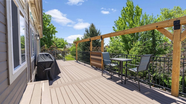 wooden terrace with area for grilling and outdoor dining space