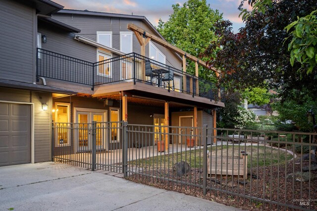 view of front of home with fence, a balcony, concrete driveway, and a garage