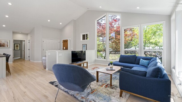 living room with baseboards, light wood finished floors, high vaulted ceiling, and recessed lighting