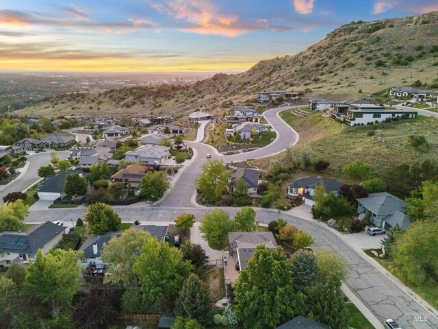 aerial view of property and surrounding area featuring nearby suburban area and a mountain backdrop