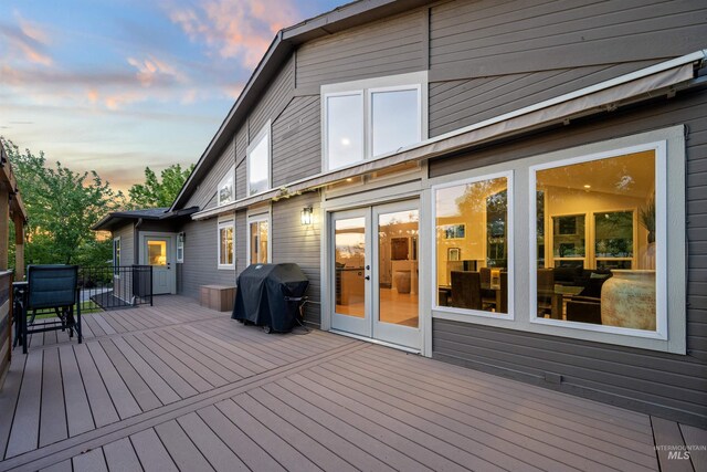 deck at dusk featuring grilling area