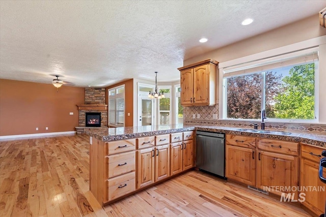 1112 W Belknap Dr, Nampa, ID 83686 - kitchen featuring dishwasher, light wood-style flooring, a fireplace, a textured ceiling, and a peninsula