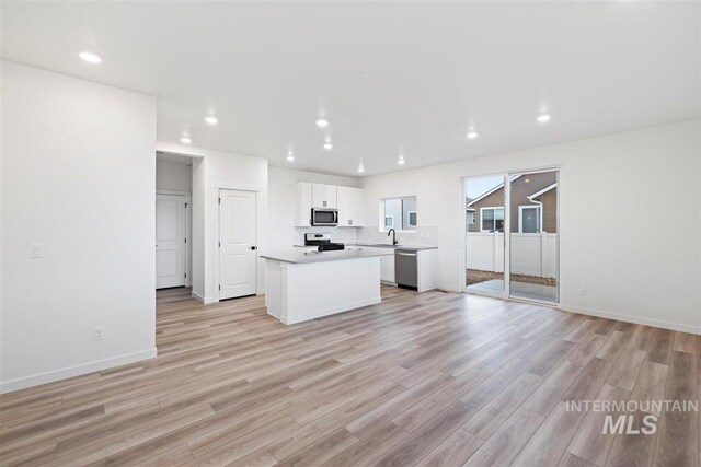 kitchen with white cabinetry, light wood-type flooring, appliances with stainless steel finishes, and a kitchen island