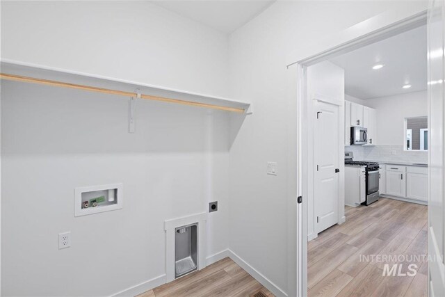 laundry area featuring washer hookup, hookup for an electric dryer, and light hardwood / wood-style flooring