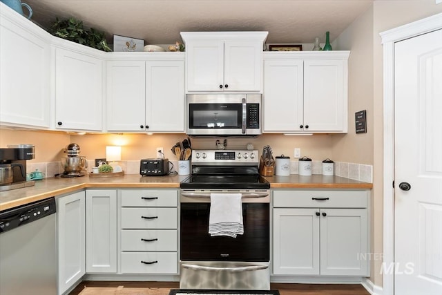 kitchen featuring stainless steel appliances and white cabinets