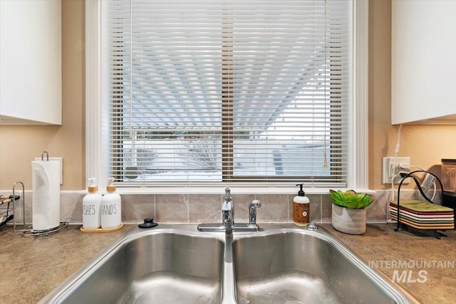 room details featuring white cabinetry and sink