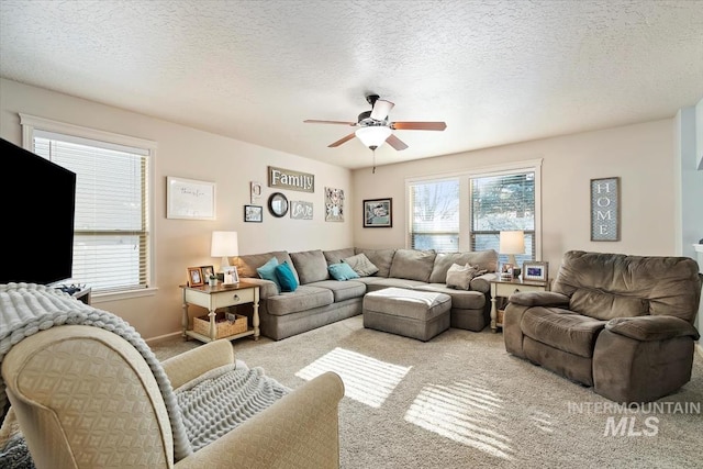 carpeted living room featuring ceiling fan and a textured ceiling