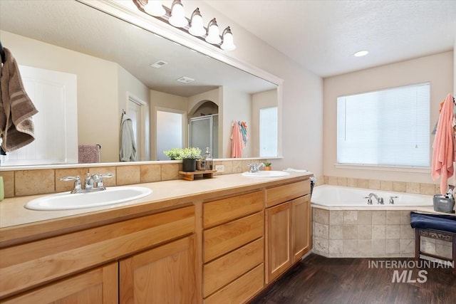 bathroom with vanity, plus walk in shower, and hardwood / wood-style floors