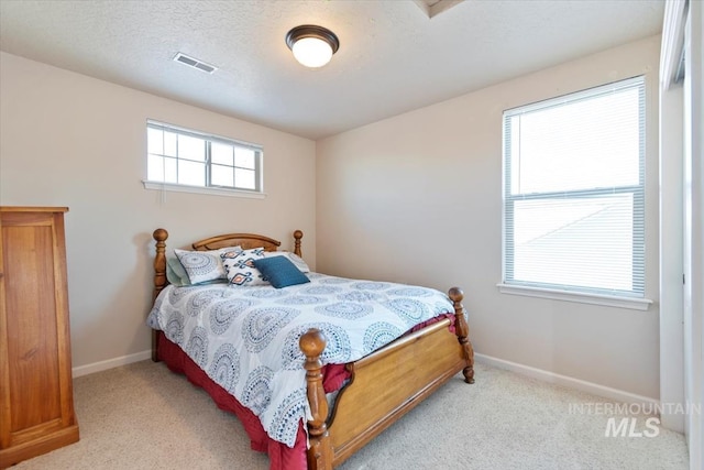 bedroom with light carpet and a textured ceiling