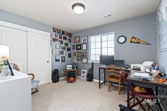 office space with light colored carpet and a textured ceiling