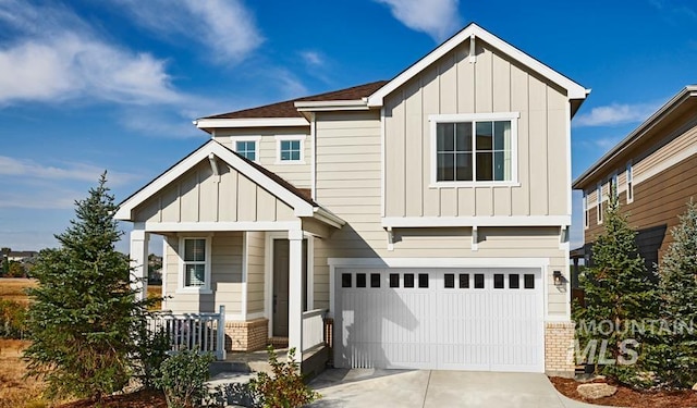 view of front of house with driveway, brick siding, board and batten siding, and an attached garage