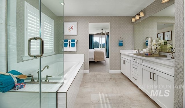 ensuite bathroom featuring wallpapered walls, a garden tub, double vanity, ensuite bath, and a sink