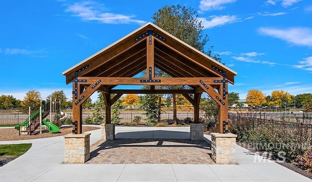 view of community featuring a gazebo, playground community, and fence