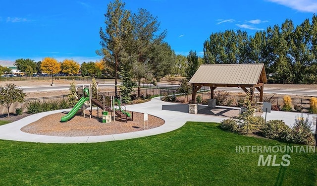 community play area with a lawn and fence