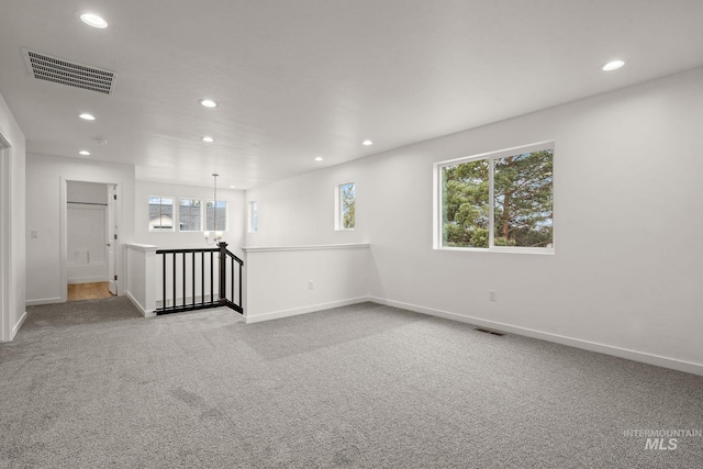 carpeted spare room featuring recessed lighting, visible vents, and baseboards