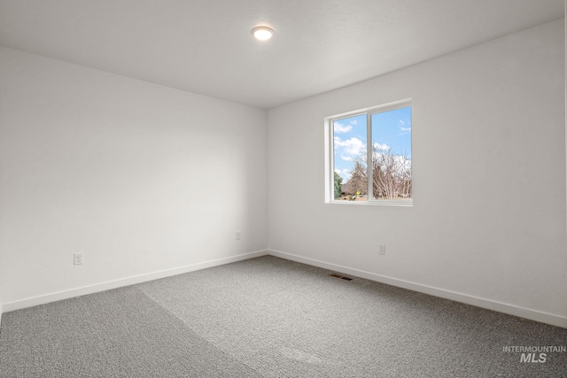 carpeted spare room with baseboards and visible vents