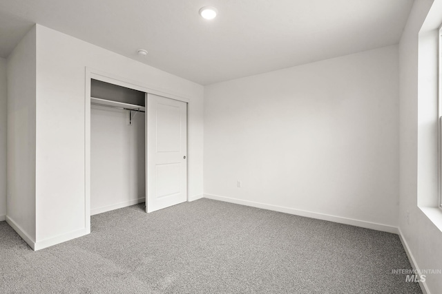 unfurnished bedroom featuring a closet, carpet flooring, and baseboards