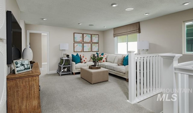 carpeted living room with recessed lighting, baseboards, and a textured ceiling