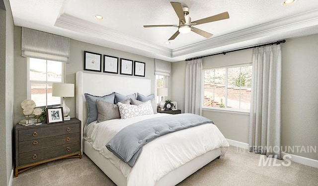carpeted bedroom featuring a raised ceiling, baseboards, and ornamental molding