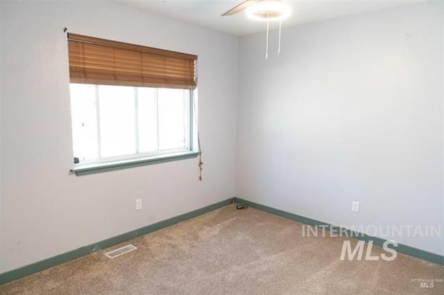 unfurnished room featuring ceiling fan and carpet floors