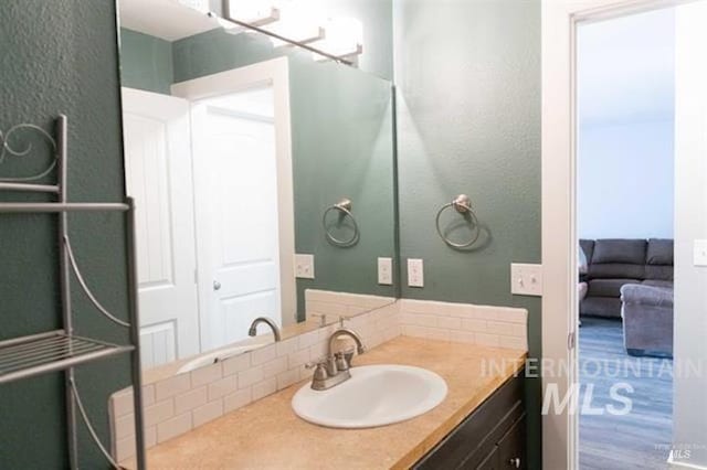 bathroom featuring vanity and tasteful backsplash