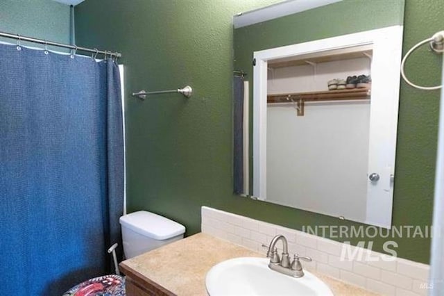 bathroom with vanity, curtained shower, and toilet