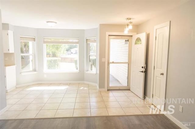 doorway to outside with light tile patterned floors