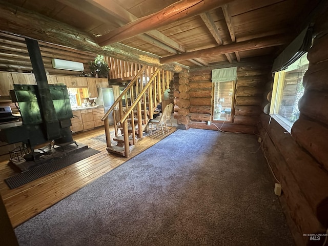2223 Glenwood Rd, Kamiah, ID 83536 - unfurnished living room with log walls, stairs, light colored carpet, and a wood stove