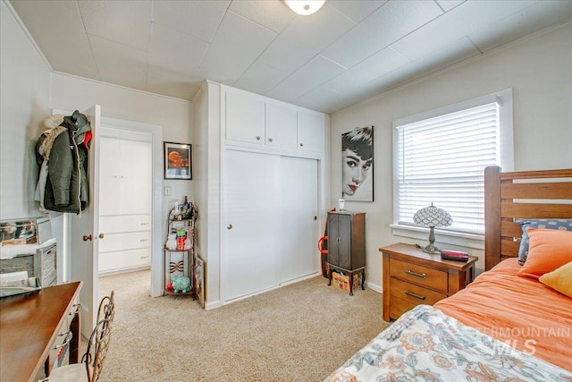 bedroom with a closet and light colored carpet