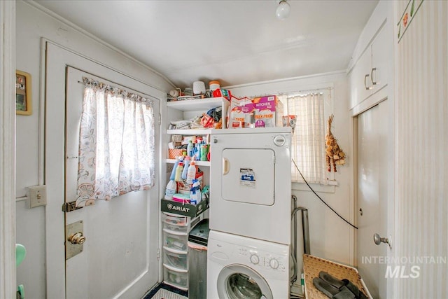 clothes washing area with stacked washing maching and dryer and crown molding