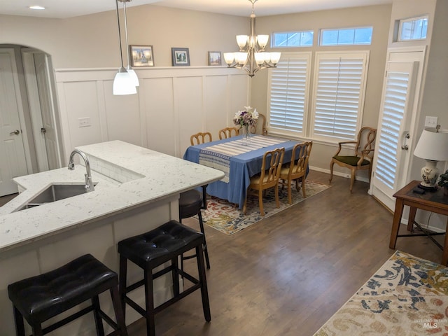 dining area with sink, a chandelier, and dark hardwood / wood-style floors